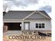 New construction home featuring light gray siding, gray shingles, and an attached two car garage at 4755 Fowler St, Acworth, GA 30101