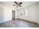 Bright bedroom featuring light gray laminate flooring, a ceiling fan, and closet at 5305 Pilgrim Point Rd, Cumming, GA 30041