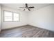 Bright bedroom featuring modern gray flooring and a ceiling fan with light fixture at 5305 Pilgrim Point Rd, Cumming, GA 30041