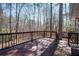 Back deck overlooking a wooded backyard with mature trees and natural surroundings at 5305 Pilgrim Point Rd, Cumming, GA 30041