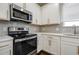 Modern kitchen featuring stainless steel appliances, white cabinets, and gray subway tile backsplash at 5350 Brooklands Dr, Lithonia, GA 30058