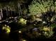 Backyard with meticulously landscaped garden illuminated by landscape lighting at night at 78 Cuthbert Ln Ne, Acworth, GA 30101