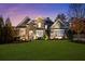 Charming two-story home with stone facade, manicured lawn, and professional landscaping at dusk at 78 Cuthbert Ln Ne, Acworth, GA 30101