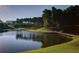 Picturesque golf course view featuring a lake, green hills, trees, and a wooden bridge on a sunny day at 78 Cuthbert Ln Ne, Acworth, GA 30101