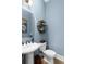 Stylish half-bathroom featuring a pedestal sink, toilet, and decorative wall shelving at 78 Cuthbert Ln Ne, Acworth, GA 30101
