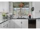 Modern kitchen with a black sink, stainless steel appliances, white cabinets, and a garden window at 78 Cuthbert Ln Ne, Acworth, GA 30101