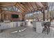 Outdoor kitchen under a wooden pergola, with bar seating, TV, grill, sink, and cabinetry at 78 Cuthbert Ln Ne, Acworth, GA 30101