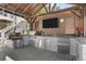 Outdoor kitchen has a pizza oven, grill, stainless steel drawers, under-counter refrigerator, and a large TV at 78 Cuthbert Ln Ne, Acworth, GA 30101