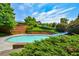 Community pool features a slide, brick accent wall, mature trees and lush landscaping in a pleasant outdoor setting at 78 Cuthbert Ln Ne, Acworth, GA 30101