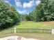 Beautiful backyard with a view of the lake, surrounded by trees and a black metal fence at 4233 Sandstone Shores Dr, Stonecrest, GA 30038