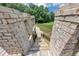A unique brick structure leads down a set of wooden stairs to provide access to the backyard and its amenities at 4233 Sandstone Shores Dr, Stonecrest, GA 30038