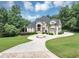 Stately home with circular driveway, manicured lawn, and lush landscaping at 4233 Sandstone Shores Dr, Stonecrest, GA 30038