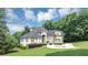 Beautiful home with circular driveway, lush landscaping, and mature trees at 4233 Sandstone Shores Dr, Stonecrest, GA 30038