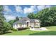 Expansive green lawn frames this stately home with circular drive and manicured landscaping at 4233 Sandstone Shores Dr, Stonecrest, GA 30038