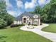 Stately two-story home features a circular driveway, manicured lawn and lush landscaping at 4233 Sandstone Shores Dr, Stonecrest, GA 30038
