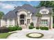 A stately home boasts a circular driveway, beautiful landscaping, and a stone facade at 4233 Sandstone Shores Dr, Stonecrest, GA 30038