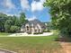 Beautifully landscaped property featuring a luxurious home with a circular driveway at 4233 Sandstone Shores Dr, Stonecrest, GA 30038