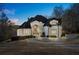 Stately white brick home featuring a circular driveway and meticulous landscaping creates an inviting curb appeal at 4233 Sandstone Shores Dr, Stonecrest, GA 30038
