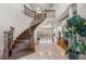 Grand foyer showcasing a curved staircase, detailed ironwork, and elegant tile flooring at 4233 Sandstone Shores Dr, Stonecrest, GA 30038