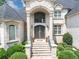 Elegant home entrance featuring a grand doorway and manicured landscaping at 4233 Sandstone Shores Dr, Stonecrest, GA 30038