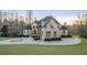 Elegant estate home with stone facade, well-manicured lawn, circular driveway, and arched entryway at 4233 Sandstone Shores Dr, Stonecrest, GA 30038
