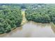 Beautiful lakefront property surrounded by dense trees showcasing a serene and secluded setting at 4233 Sandstone Shores Dr, Stonecrest, GA 30038