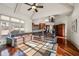 Open-concept living room with a vaulted ceiling, hardwood floors, and a large leather sectional at 4233 Sandstone Shores Dr, Stonecrest, GA 30038