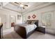 Relaxing main bedroom features a decorative tray ceiling and exterior views at 4233 Sandstone Shores Dr, Stonecrest, GA 30038