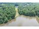 An aerial view of the pond shows a home with a large lawn leading to the waterfront at 4233 Sandstone Shores Dr, Stonecrest, GA 30038
