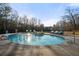 Outdoor pool and hot tub surrounded by lounge chairs and mature trees create a serene backyard oasis at 4233 Sandstone Shores Dr, Stonecrest, GA 30038