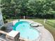 Aerial view of a sparkling swimming pool and jacuzzi surrounded by lush greenery at 4233 Sandstone Shores Dr, Stonecrest, GA 30038