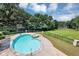 Inviting backyard pool with a spa, set against a backdrop of lush greenery and a tranquil lake at 4233 Sandstone Shores Dr, Stonecrest, GA 30038