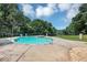 Backyard pool with clear water and a hot tub, surrounded by a black metal fence and landscaping at 4233 Sandstone Shores Dr, Stonecrest, GA 30038