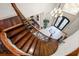 Elegant curved staircase with iron railing, hardwood steps, and soaring ceilings at 4233 Sandstone Shores Dr, Stonecrest, GA 30038