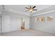 Bright bedroom with tray ceiling, fan, neutral walls and carpet, showing doorway to bathroom at 6945 Melody Ridge Rd, Buford, GA 30518