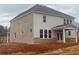 Rear view of a home with brick and gray siding, large windows, and a covered patio at 6945 Melody Ridge Rd, Buford, GA 30518