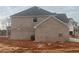 Side view of a new two-story home featuring brick and gray siding under a cloudy sky at 6945 Melody Ridge Rd, Buford, GA 30518