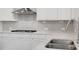 Well-lit kitchen featuring gray subway tile backsplash and stainless steel sink at 6945 Melody Ridge Rd, Buford, GA 30518