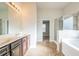 Bright bathroom featuring a double sink vanity, a glass-enclosed shower, and a soaking tub at 2436 Planters Mill Way, Conyers, GA 30012