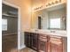 Bathroom with a double sink vanity with a large mirror and dark wood cabinets at 2436 Planters Mill Way, Conyers, GA 30012