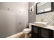 Elegant half bath with a black vanity, stylish mirror, white vessel sink, gold fixtures, and gray walls at 2436 Planters Mill Way, Conyers, GA 30012