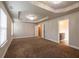 Expansive bedroom featuring a tray ceiling, chandelier, two windows, and an open doorway to the bathroom at 2436 Planters Mill Way, Conyers, GA 30012