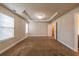 Large bedroom with tray ceiling, chandelier, two windows, a neutral color scheme, and an open doorway at 2436 Planters Mill Way, Conyers, GA 30012