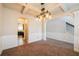 Spacious dining area with decorative wainscoting, modern chandelier, and archway to kitchen at 2436 Planters Mill Way, Conyers, GA 30012