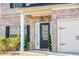 Inviting front entrance featuring a stylish black door with decorative plants and a brick facade at 2436 Planters Mill Way, Conyers, GA 30012