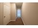 Neutral hallway featuring carpet, white trim, doors, and an arched entryway to another room at 2436 Planters Mill Way, Conyers, GA 30012