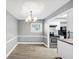 Dining room with gray walls and modern chandelier open to kitchen at 117 Lablanc Nw Way, Atlanta, GA 30327