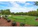 Well-manicured putting green surrounded by mature trees and landscaping offering a serene setting for golfers at 117 Lablanc Nw Way, Atlanta, GA 30327