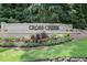 Welcoming Cross Creek sign surrounded by flowers and mature trees, located at the community entrance at 117 Lablanc Nw Way, Atlanta, GA 30327