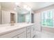 Bright bathroom features a double sink vanity with white countertop, and window view of trees at 1604 Ruskin Way, Marietta, GA 30062